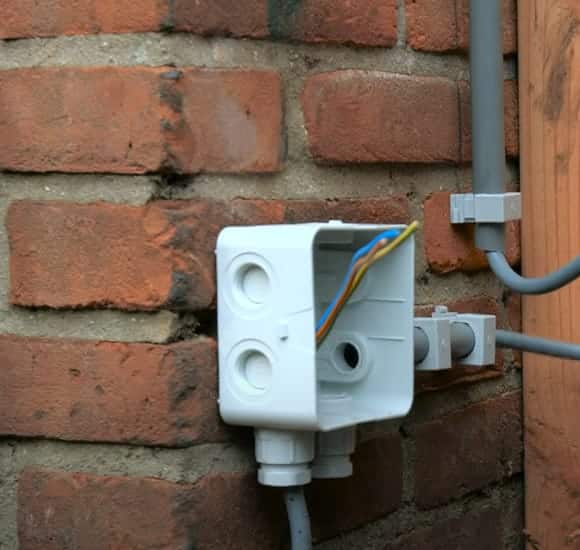 Spatwaterdicht buitenstopcontact gemonteerd op een bakstenen gevel