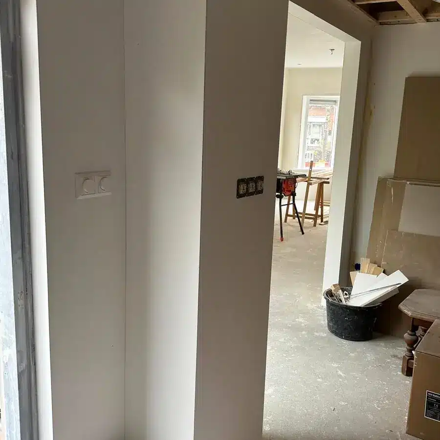 Doorkijk in een woning in verbouwing met nieuw geplaatste stopcontacten en schakelaars