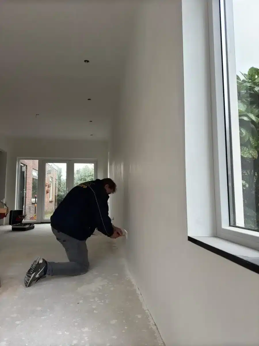 Monteur van MDK Elektro plaatst een wandcontactdoos tijdens een renovatie